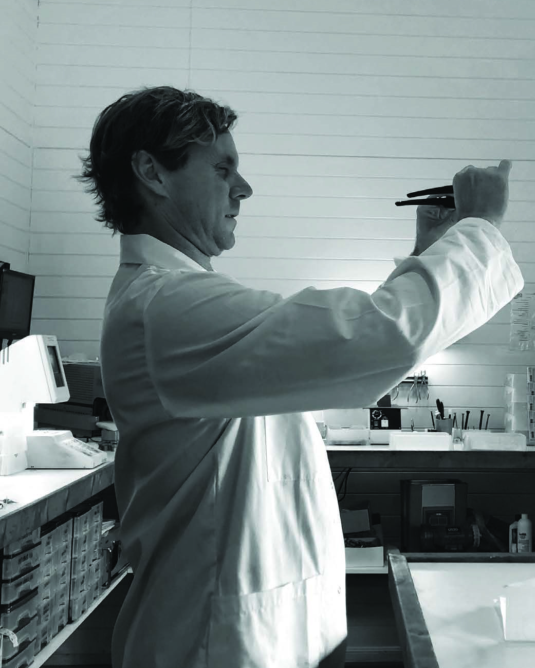 An optical technician checking the quality of the lens prescription in the lab after manufacturing